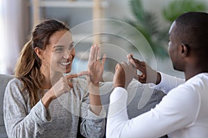 Smiling mixed ethnicity couple talking with sign finger hand language photo