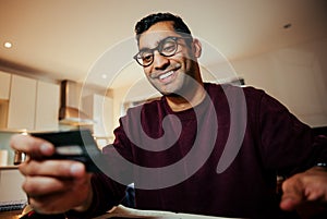 Smiling mixed race business man making online purchase holding credit card