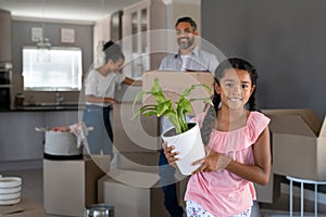 Smiling mixed race girl moving house with parents