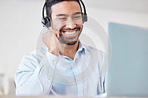 Smiling mixed race male call centre agent smiling while wearing a wireless headset. Young man working as a customer