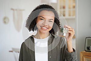 Smiling mixed race teen girl tenant or homeowner holds keys to new home. Rental housing, mortgage