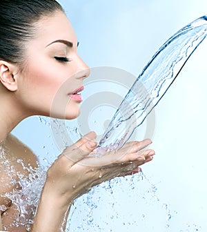 Smiling model girl under splash of water