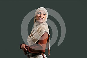 Smiling modern, beautiful muslim woman on gray background. Copy space
