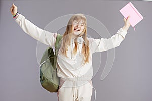 smiling modern teenage girl with raised arms rejoicing