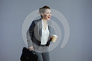 smiling modern woman employee running against grey background