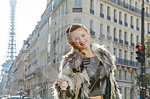 Smiling modern woman in fur coat in Paris, France