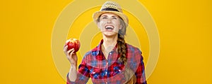 Smiling modern woman grower with an apple looking at copy space