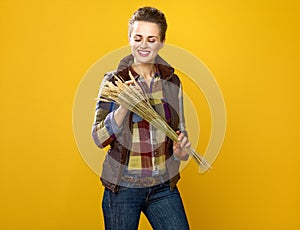 Smiling modern woman grower observing wheat spikelets