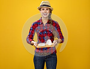 Smiling modern woman grower showing trey with soft white cheese