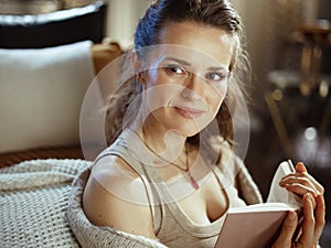 Smiling modern woman at modern home in sunny winter day