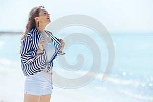 smiling modern woman on seashore enjoying tranquility