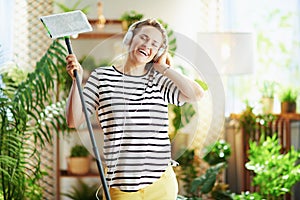 Smiling woman in striped shirt in sunny day housecleaning photo