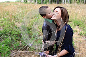 Smiling mom accepting a kiss on the cheek from her son