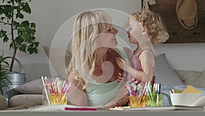 Smiling mom hugs her daughter child, preschool learning activities at home, concept of healthy growing, support from caring adults