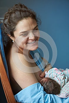 Smiling mother with breastfeeding baby