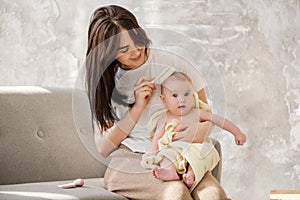 Smiling mother brush soft baby girl hair