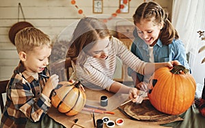Smiling mother with children creating jack-o-lantern during Halloween celebration at home