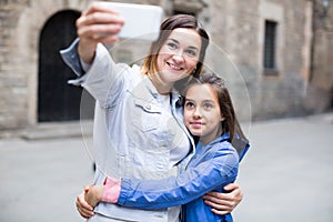 Smiling mother and daughter taking photo