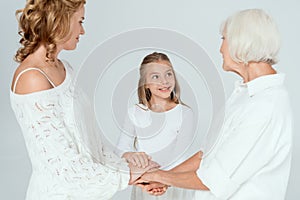 smiling mother, grandmother and granddaughter holding