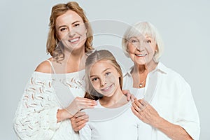 smiling mother and grandmother hugging granddaughter