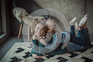 Smiling mother with her daughter in the room on the carpet