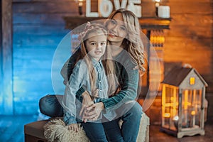 Smiling mother with her daughter in the room on the carpet