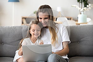 Smiling mother and kid having fun shopping online with laptop