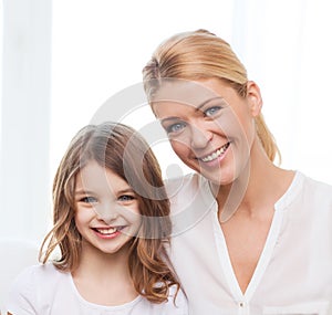 Smiling mother and little girl with laptop at home