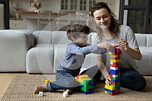 Smiling mother and little son playing with colorful construction toys