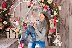 Smiling Mother Playing With Baby Son At Home