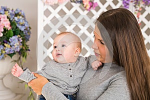 Smiling Mother Playing With Baby Son At Home