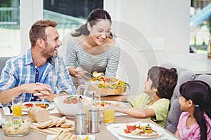Smiling mother serving food to children