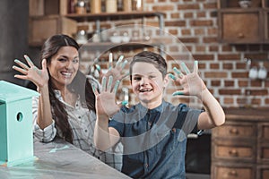 Smiling mother and son showing their finger covered