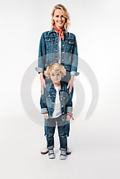 smiling mother and son standing and looking at camera