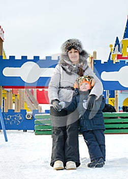 Smiling mother and son in a winter playground