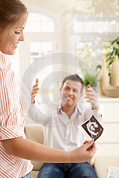 Smiling mother with ultrasound image