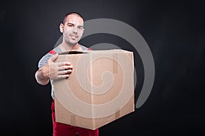 Smiling mover man holding big cardboard box