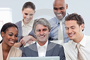 Smiling Multi-ethnic business group using a laptop