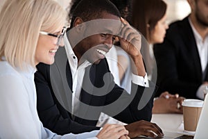 Smiling multi-ethnic coworkers working together in office using photo