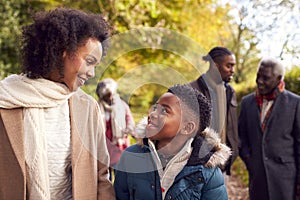 Smiling Multi-Generation Family Having Fun Walking Through Autumn Countryside Together