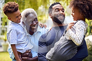 Smiling Multi-Generation Family At Home In Garden Together