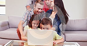 Smiling multi generation family using laptop