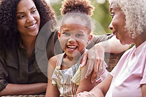 Smiling Multi-Generation Female Family At Home In Garden Together