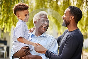 Smiling Multi-Generation Male Family At Home In Garden Together