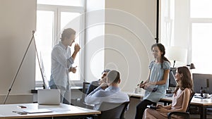 Smiling multi racial teammates attend briefing in coworking office