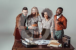 smiling multicultural retro styled journalists looking at camera in office