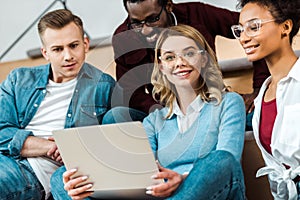 Multicultural students with laptop in lecture hall