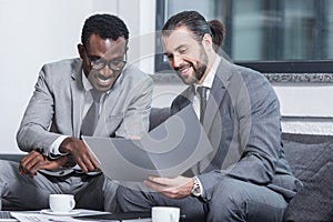 smiling multiethnic businessmen reading document