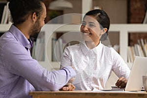 Smiling multiethnic businesspeople handshake getting acquainted at meeting