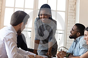 Smiling multiethnic colleagues discuss business ideas at meeting